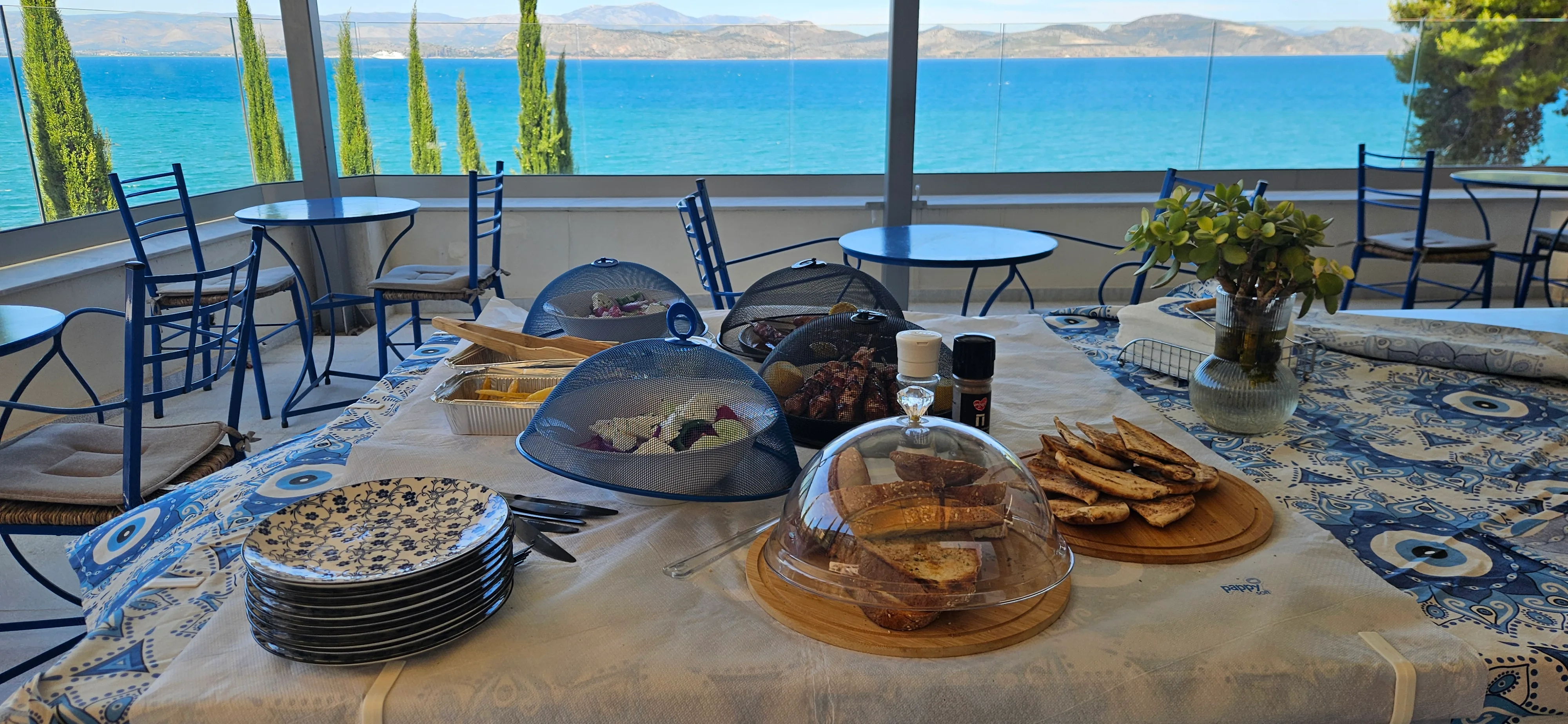 Breakfast table with covered dishes overlooking the blue gulf
