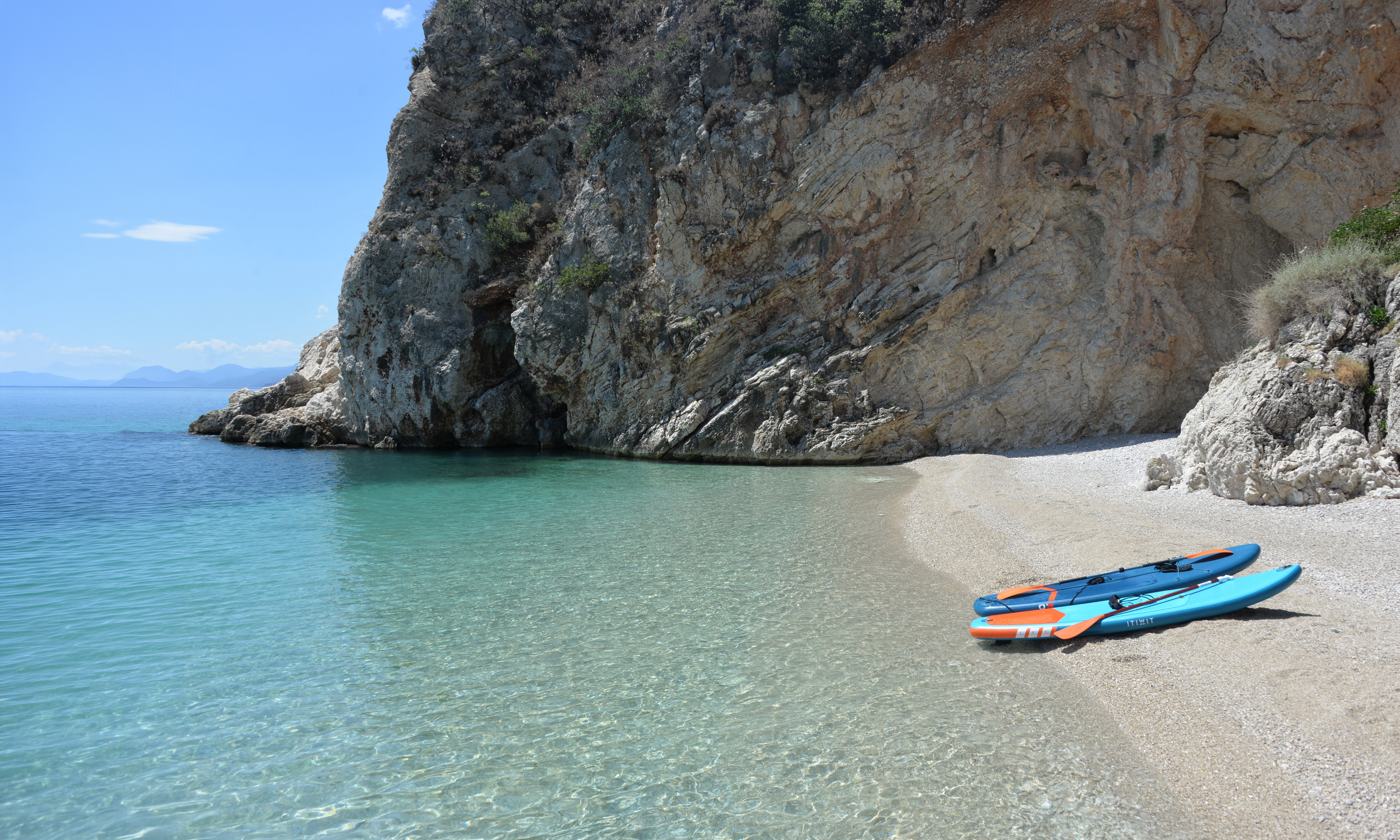 Paddleboards on a sheltered beach beside turquoise water