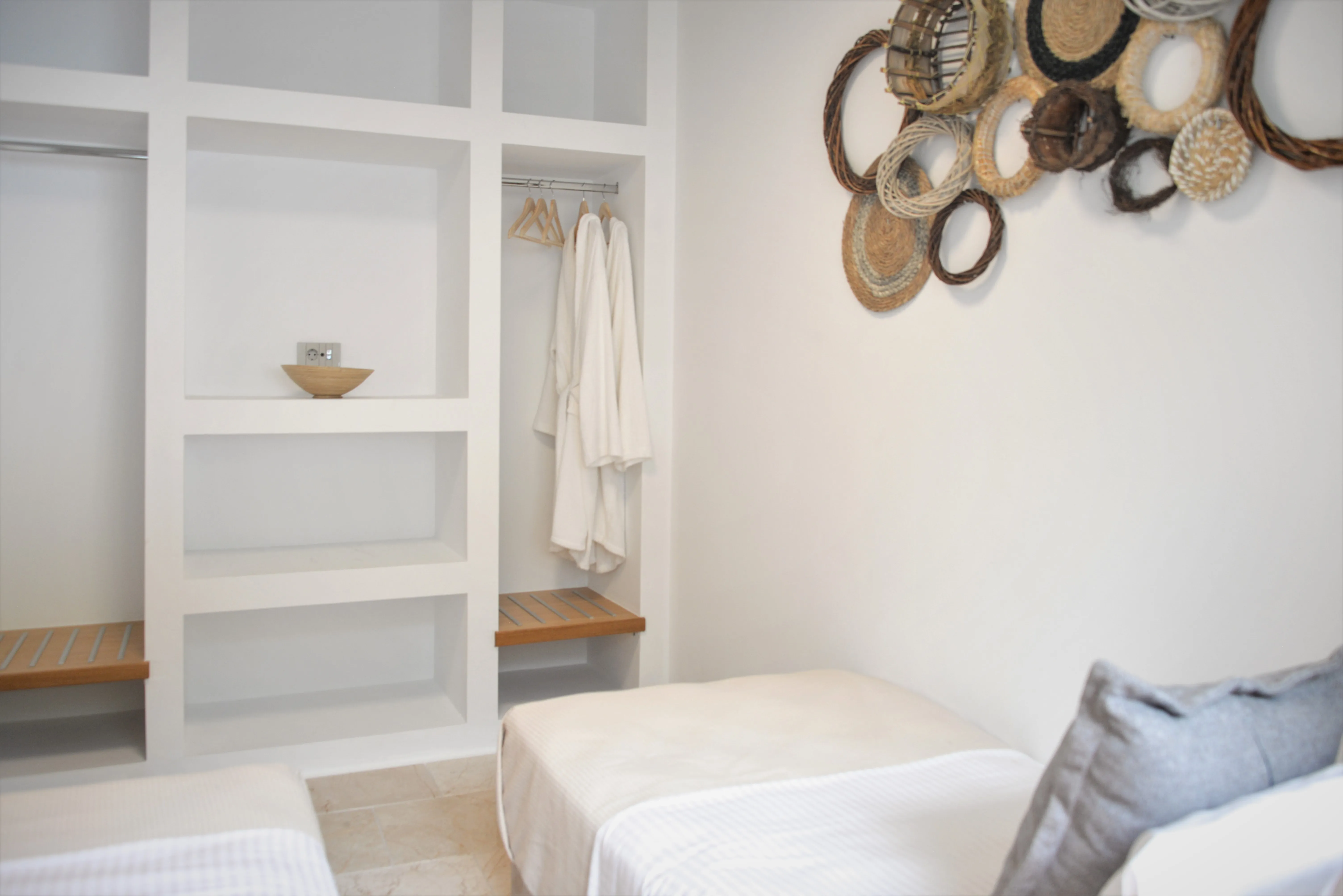 Zweites Schlafzimmer mit Einzelbett und offenem Schrank mit Bademänteln