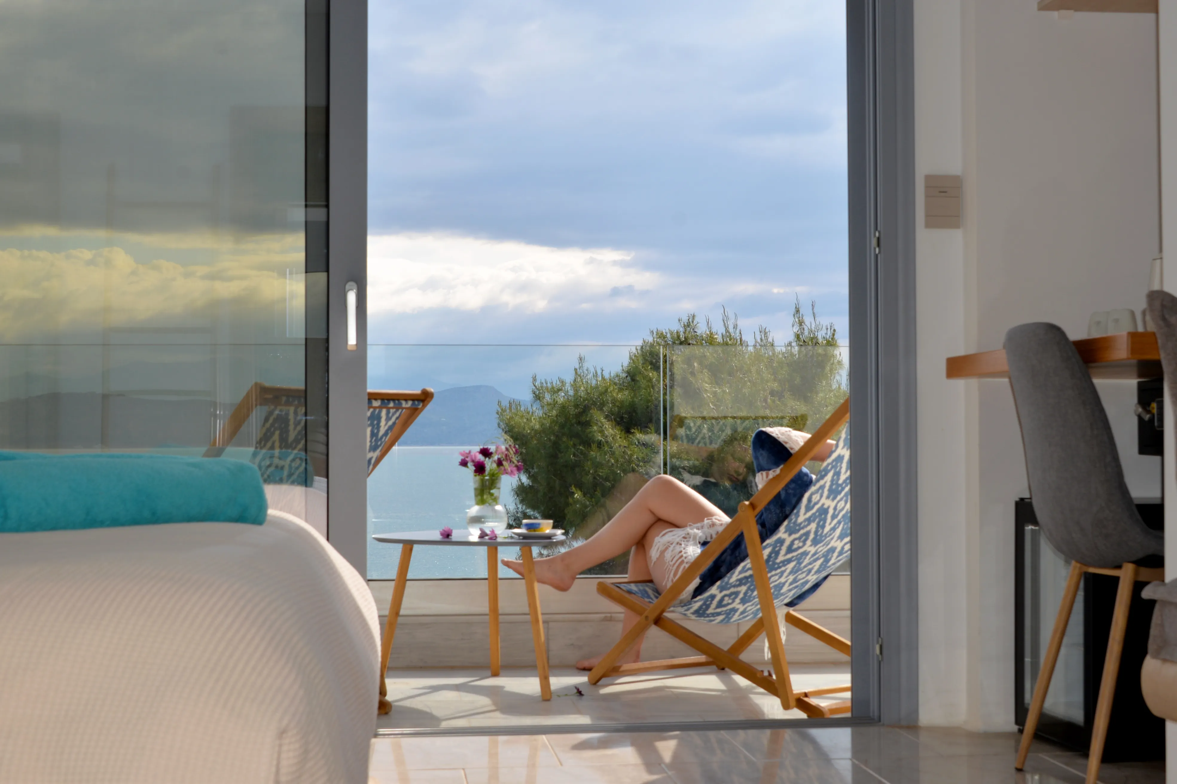 Guest with morning coffee on the corner balcony of Euros above the gulf