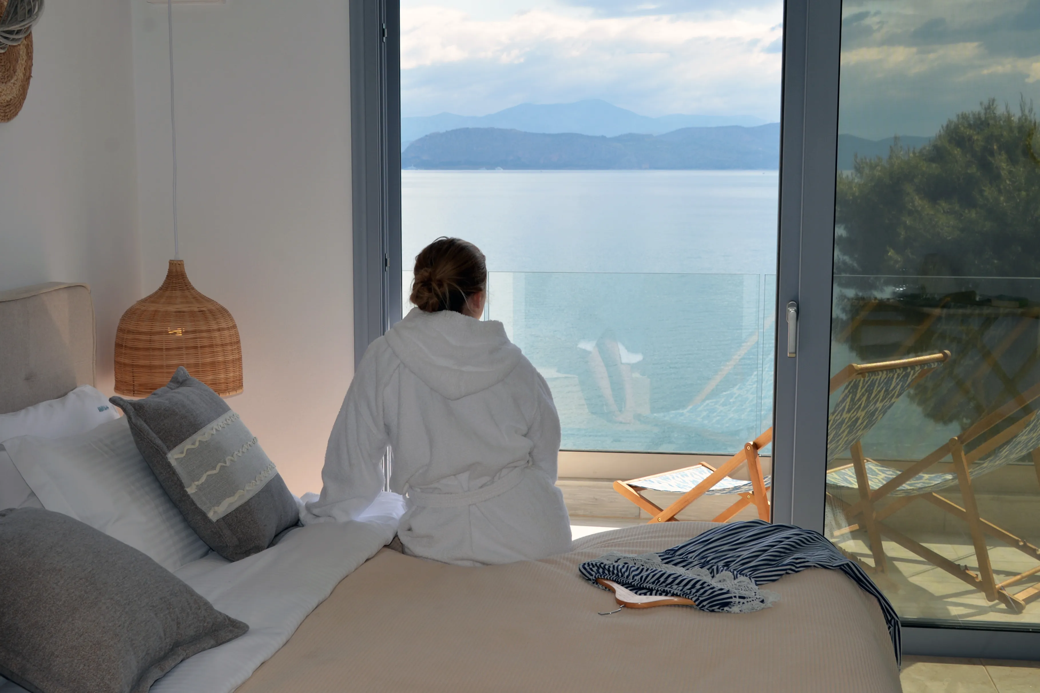 Guest sitting on the bed of Euros, looking out to the sea