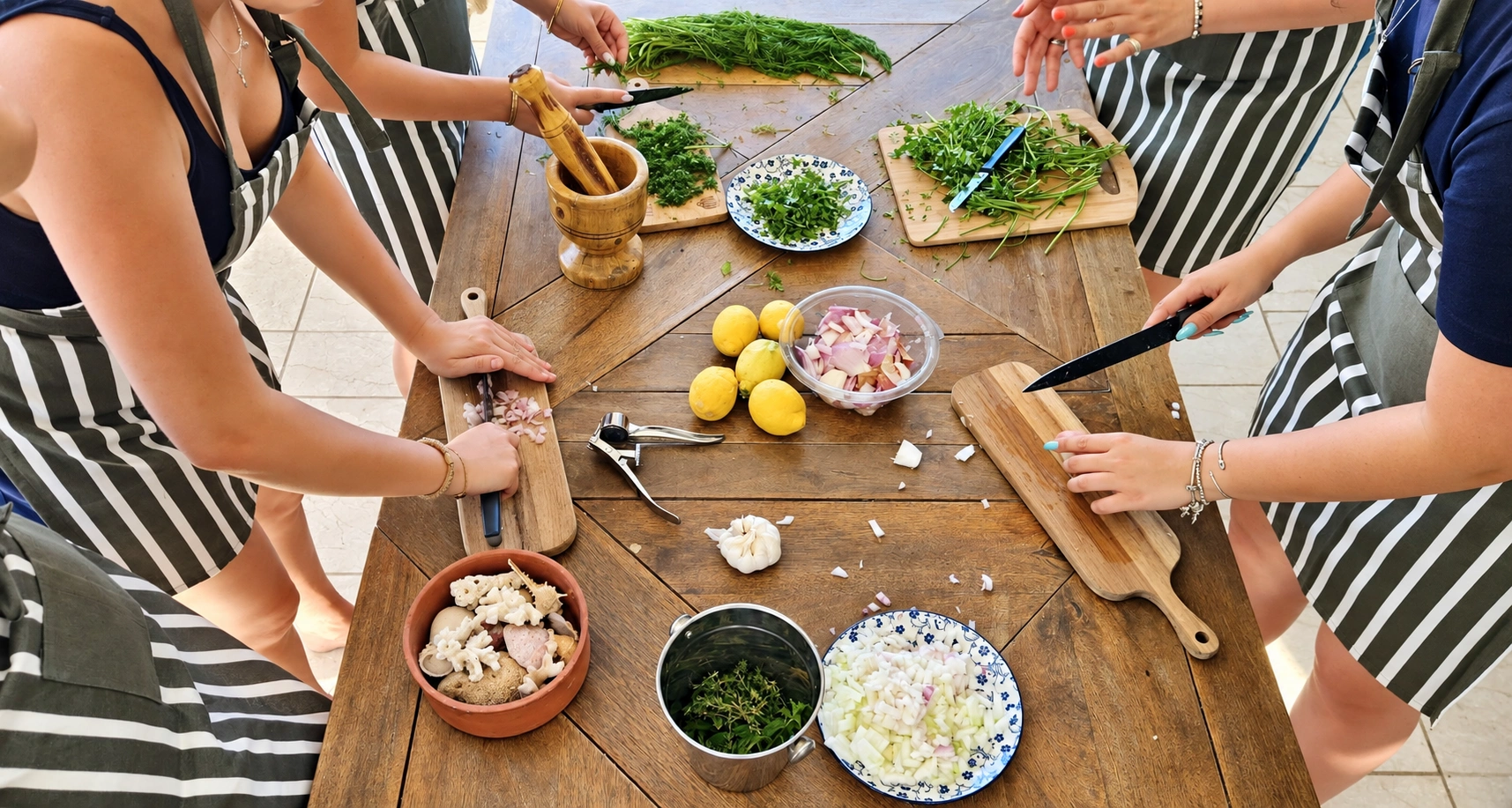 Guests preparing Greek ingredients together at a wooden table